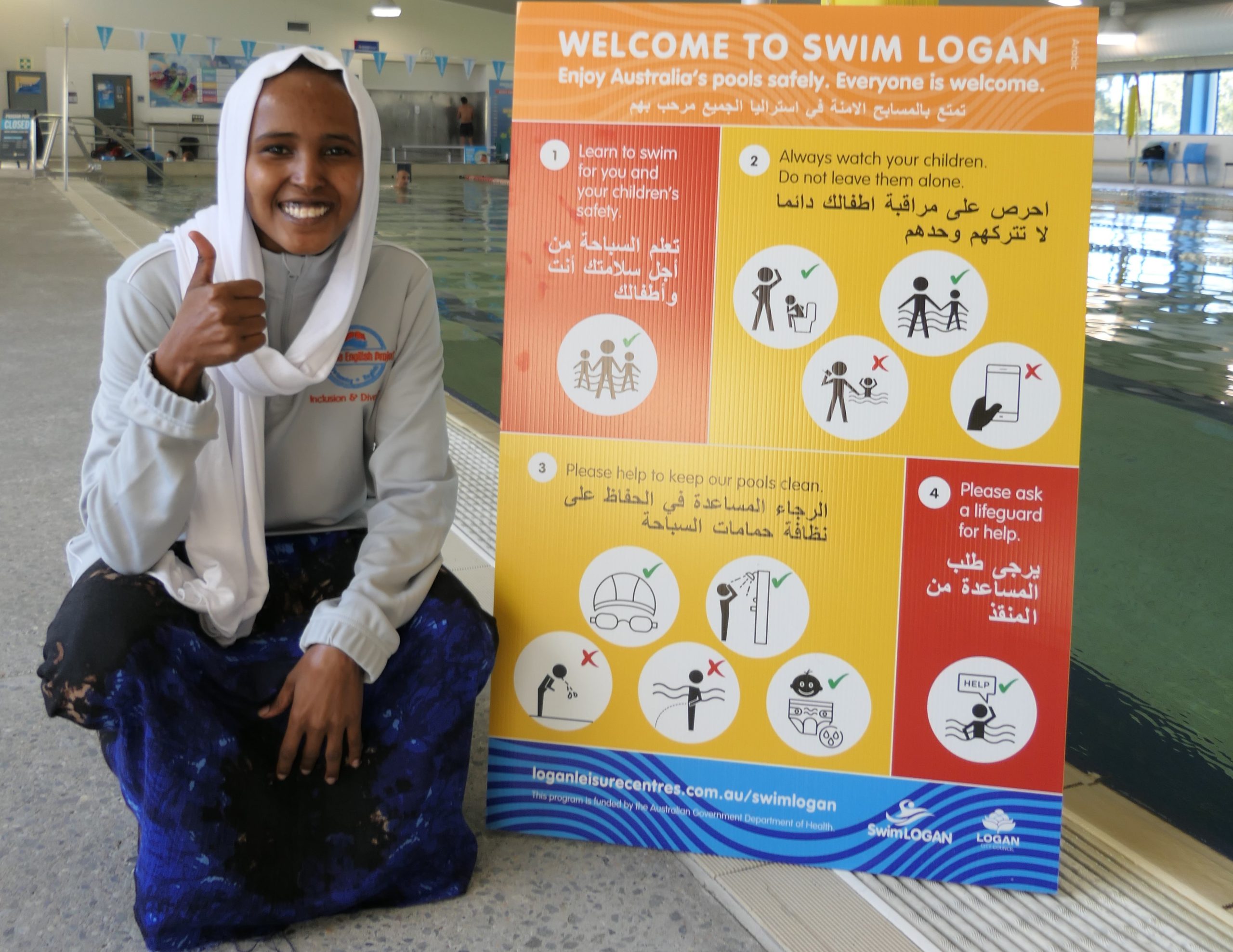 Khadra Awil with a water safety sign at Gould Adams Park Aquatic Centre