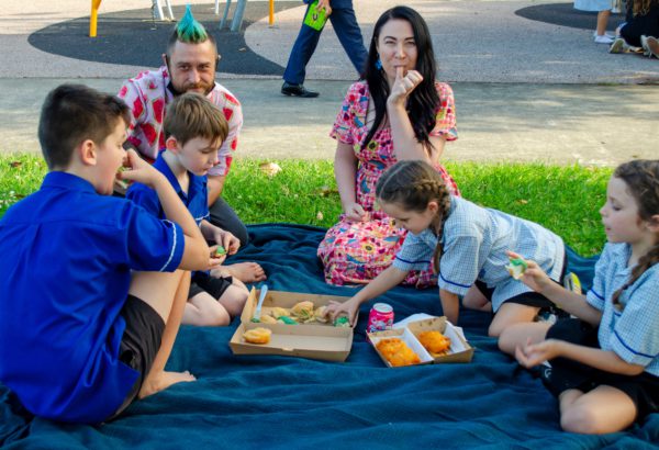 Division 3 Councillor Mindy Russell, Daisy Hill State School teacher aide Luke Luxford and students from the school enjoy a bite to eat at the soon to be refurbished Brough Place.