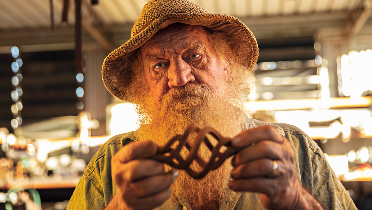 Local boilermaker John Howes in his workshop looking at a metal sculpture