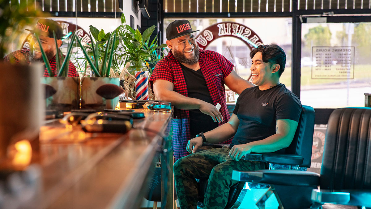 Spasifik Cuts barber Nicky Pati smiling with customer in chair