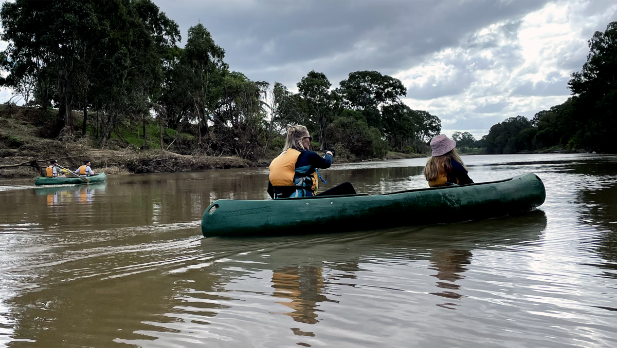 An image of Barb McCandlish and Bailey Snelgrove (foreground) and Jake Barkey and Steven Dridan paddling along the Logan River.