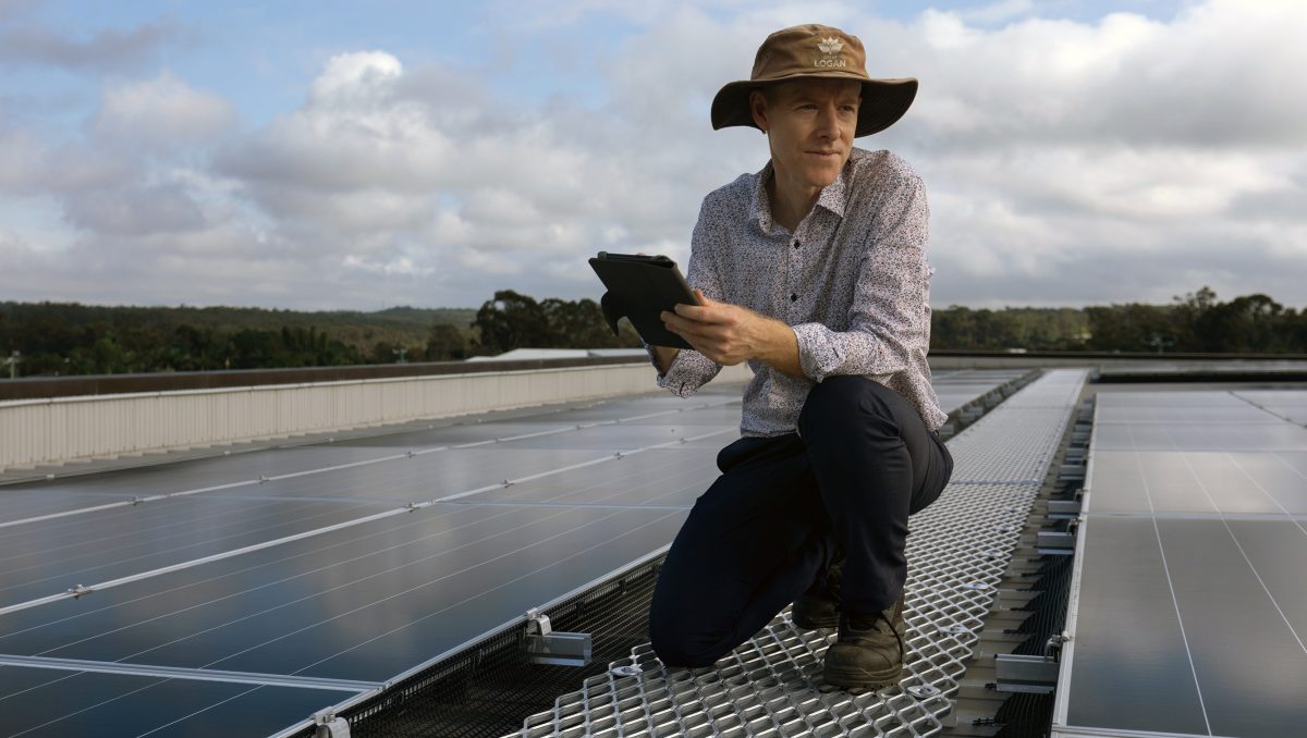 An image of a Council worker inspecting solar panels to illustrate that Logan City Council will increase its solar harvesting capacity as it aims to be carbon neutral by the end of the year.