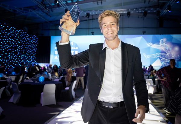 Man holding up award on runway