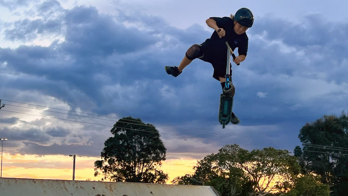 An image of Calais Nielsen, 12, of Bribie Island, doing a scooter trick at Doug Larsen Park in Beenleigh.