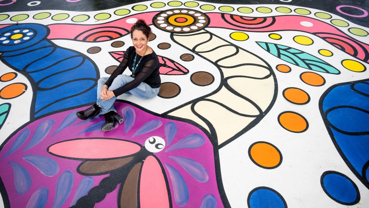 Sally sitting in the middle of part of Wander Free ground mural.