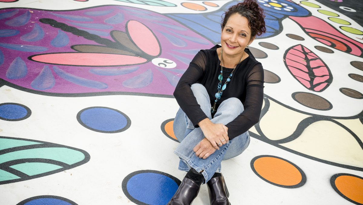 Sally Terare sitting in the middle of Wander Free ground mural.