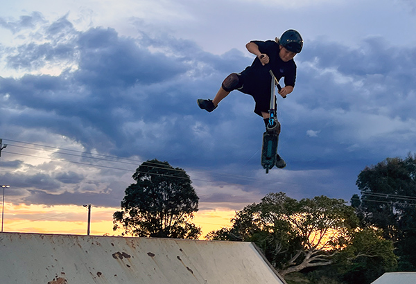 An image of Calais Nielsen, 12, of Bribie Island doing a high-flying scooter trick at Doug Larsen Park in Beenleigh
