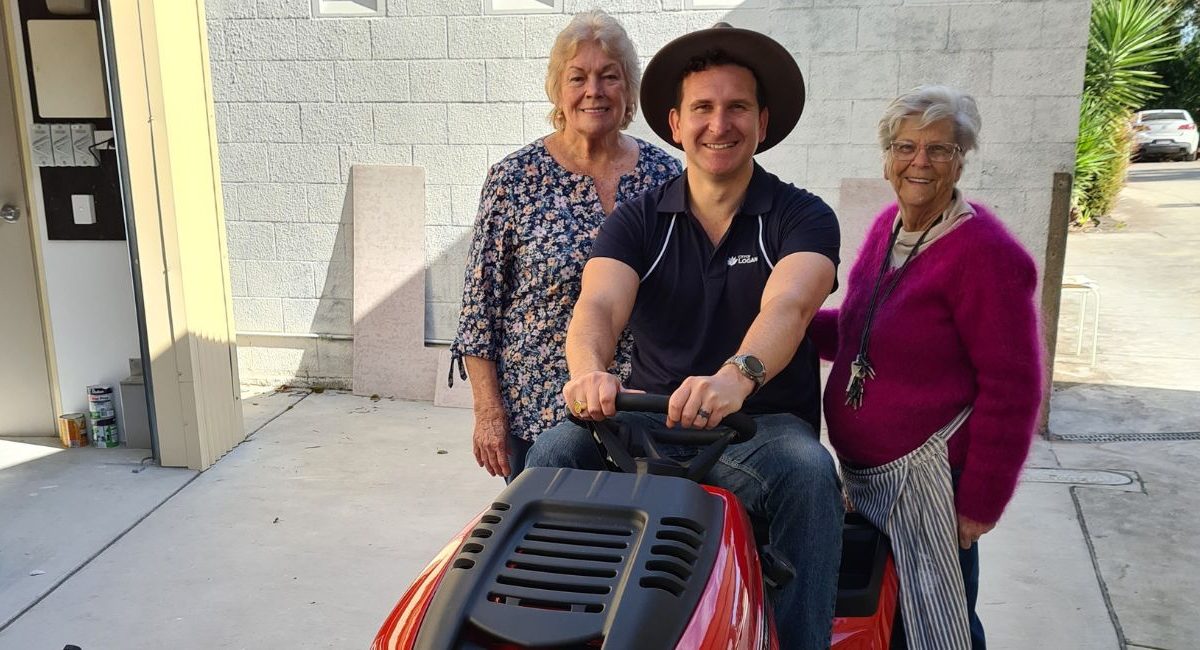 Cr Tony Hall with local residents and their new mower