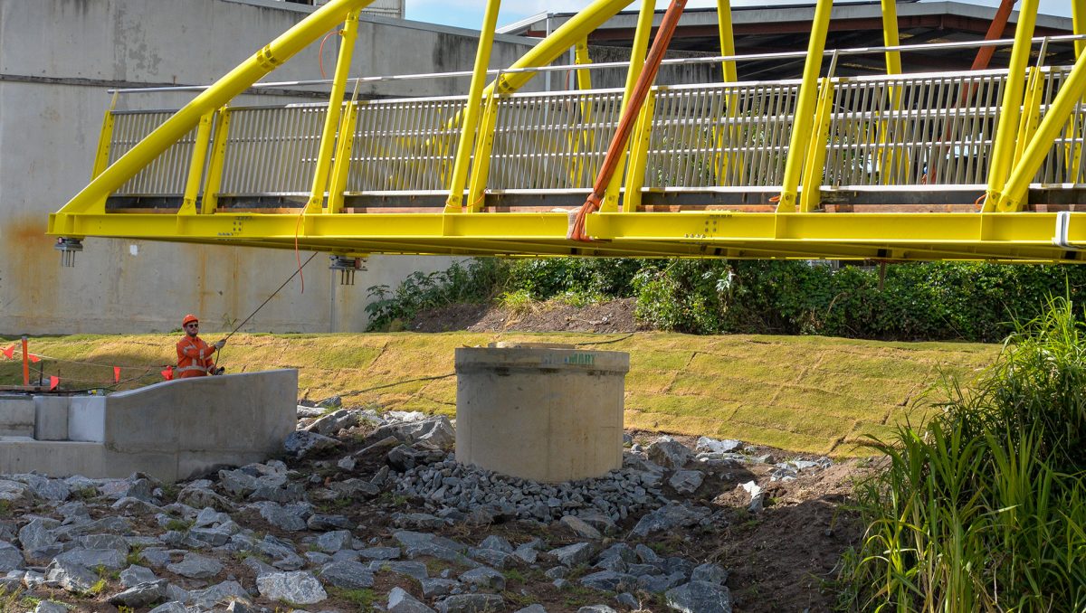 A worker helps position the new bridge over Slacks Creek.