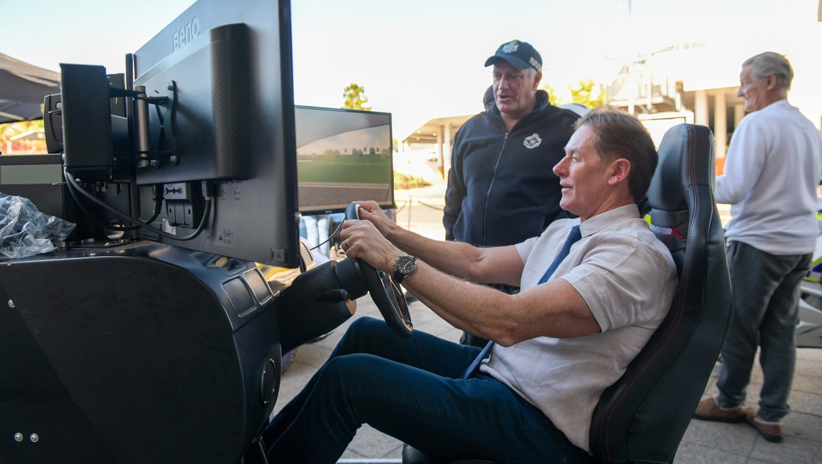 City of Logan Mayor Darren Power in the hot seat of a driving simulator as Senior Constable Tony Fishburn watches on.
