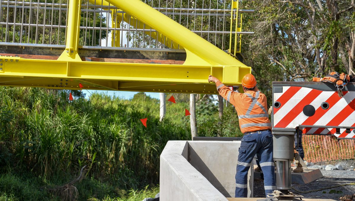 Workers fine tune the position of the bridge.