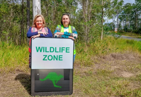 Deputy Mayor Laurie Koranski (left) and Albert Valley Wilderness Society member Judy Kohler with one of the wildlife advisory signs being installed in Cedar Creek