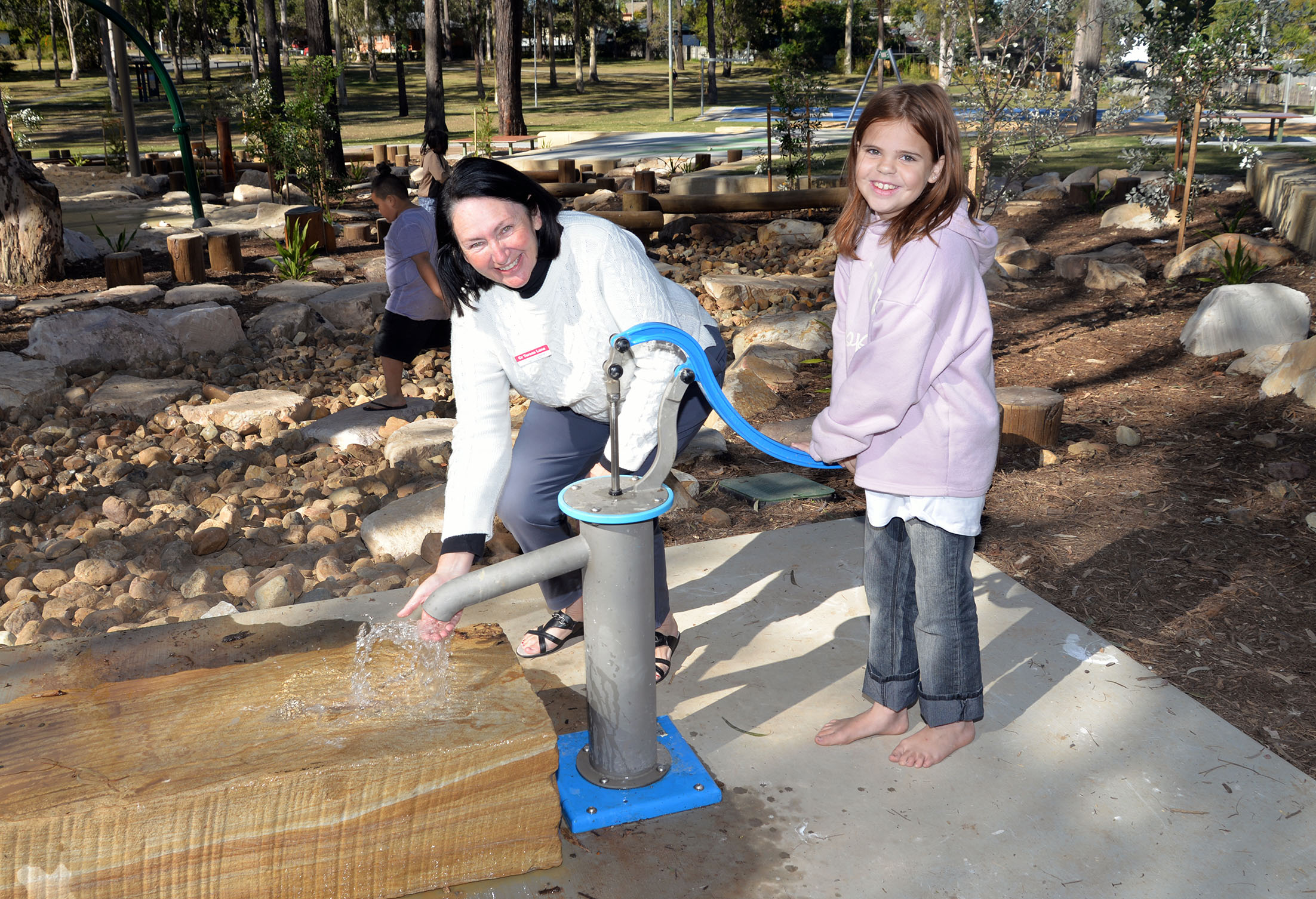 Councillor Teresa Lane explores one of the new water play pumps with Jade Harper, 10, in Eridani Park at Kingston which has undergone a $1.7 million upgrade.