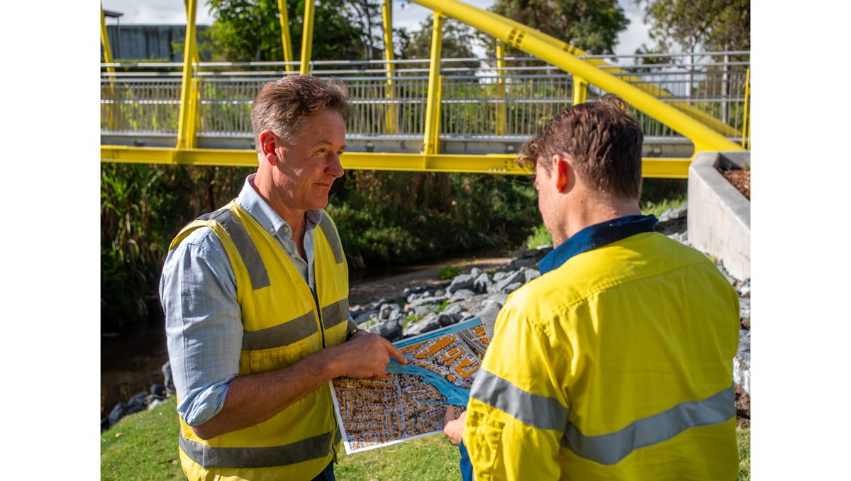 City of Logan Mayor Darren Power examines a flood-risk map with hydrographer Dominic Morris at Slacks Creek.