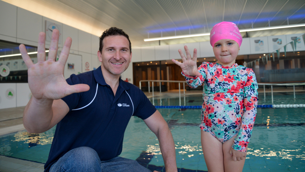 Cr Tony Hall and Logan swim school participant Poppy Ludski get ready to dive into summer with Kids Alive Do the Five.