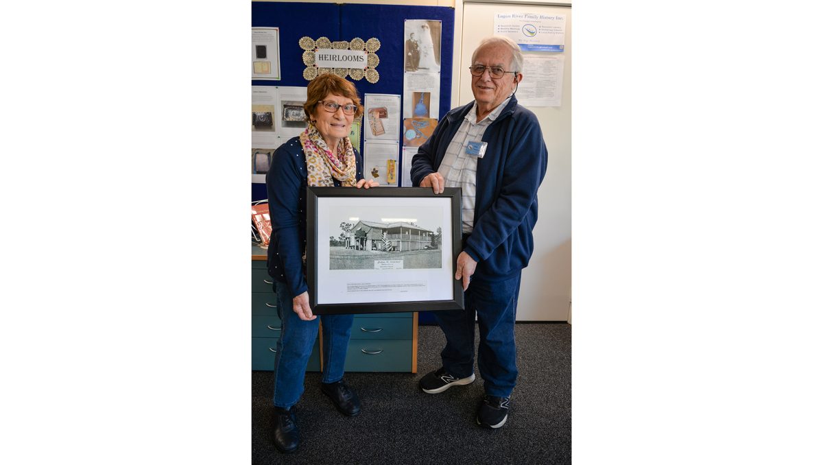 Long-serving Logan River Family History Society member Elizabeth Lamb and President Rob Thomson with a line drawing by the late Keith Schmidt of the Schlort family of Waterford.