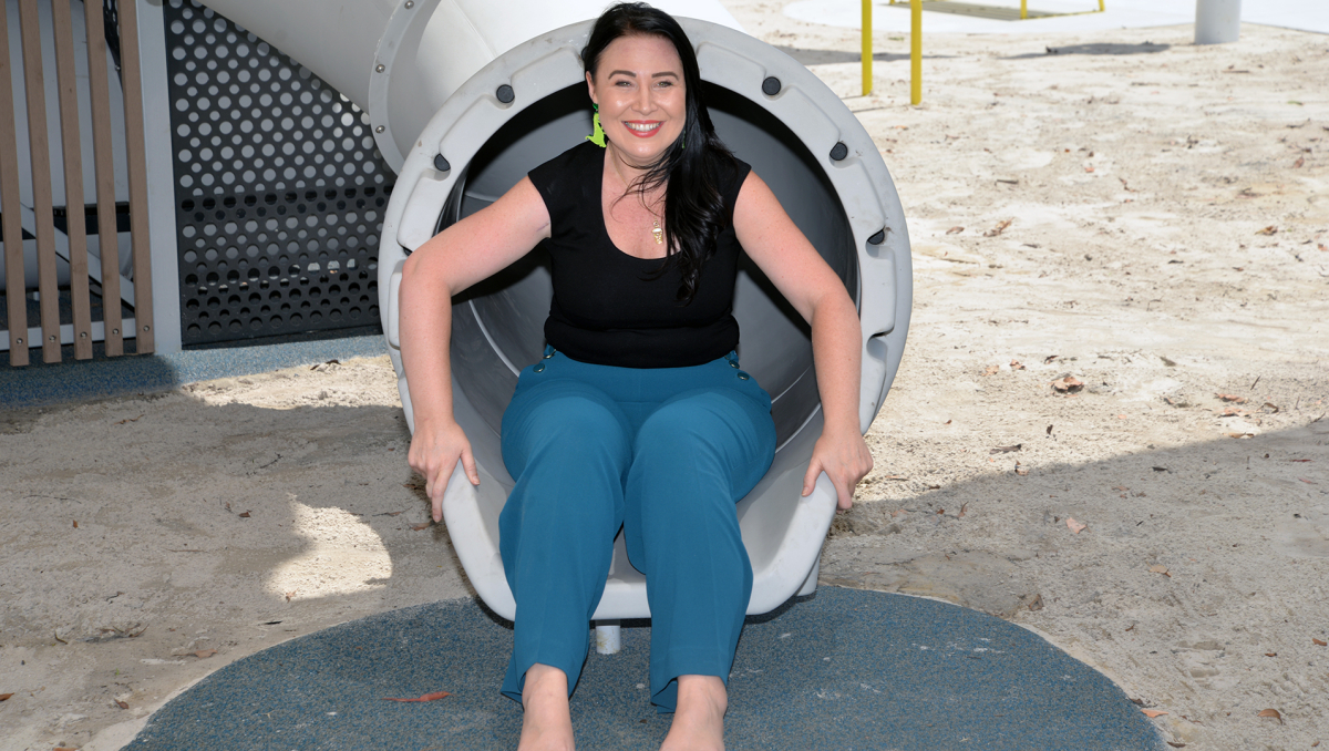 An image of Cr Mindy Russell trying out the new playground slide.