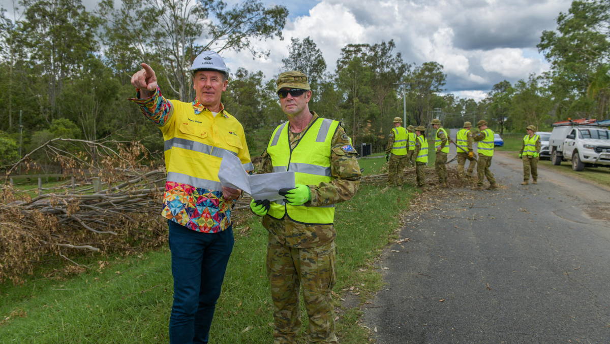 An image of Mayor Darren Power (left) and ADF Sergeant Jason Hatcher, whose Alpha Team were on storm clean-up in the Logan suburb of Cedar Grove today.