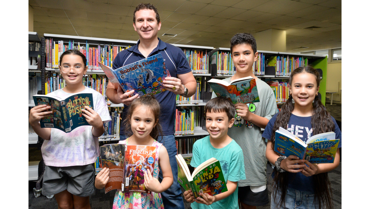 Lifestyle Chair Councillor Tony Hall (back right) highlights Logan Libraries membership with Cassella family members Giovanni (back right) and Rosalena and (from front left) Malina, Selena and Luciano.