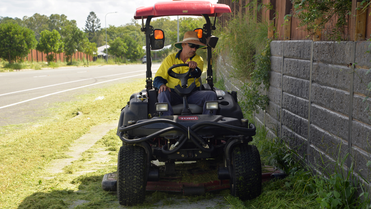 An image of David Franz on a ride-on mower as he gives an overgrown footpath a much-needed trim.