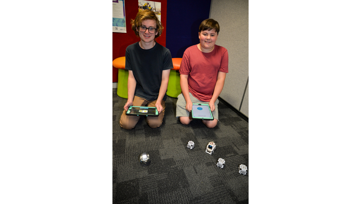 William (left) and Samuel Burgess with the robots which will be part of Logan Libraries' school holiday program in April.