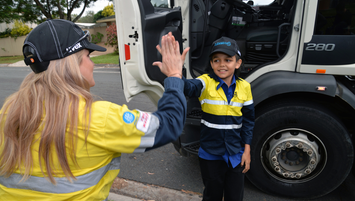 An image of Ethan Nilsen giving a high-five to Cleanaway's Emily Sime.