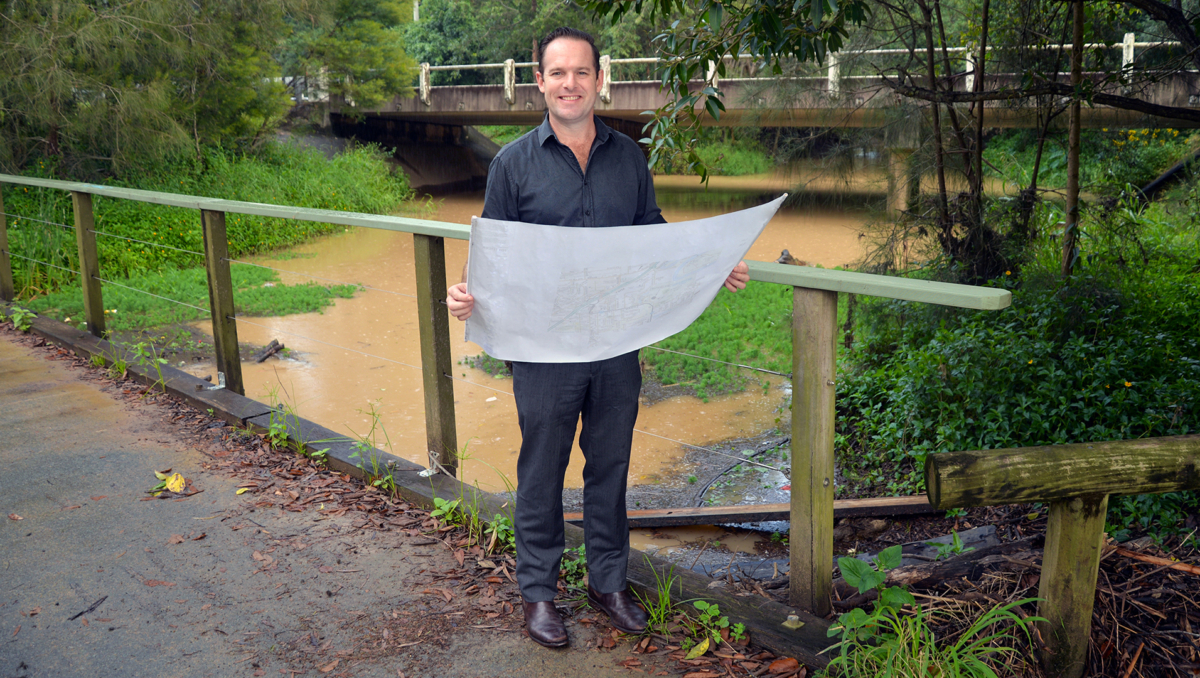 An image of Mayor Jon Raven looking at updated flood-risk mapping for Windaroo Creek at Noyer Park.