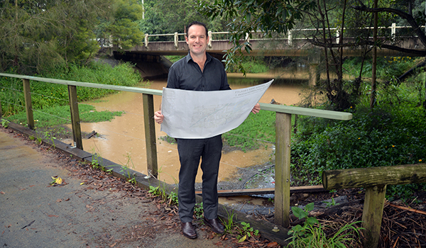 An image of Mayor Jon Raven looking at updated flood-risk mapping for Windaroo Creek at Noyer Park.