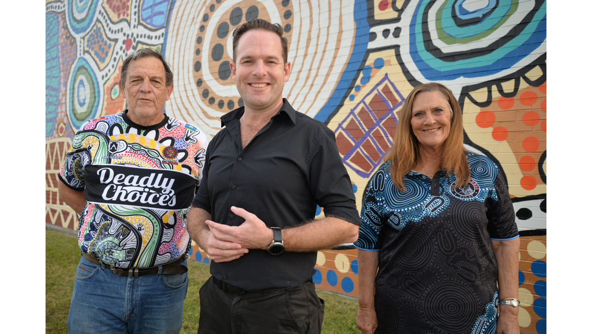 City of Logan Mayor Jon Raven (centre), Uncle Terry Stedman (left) and Aunty Sheryl Banks from the Logan District Aboriginal & Torres Strait Islander Corporation for Elders invite the community to join in NAIDOC Day 2024 celebrations.