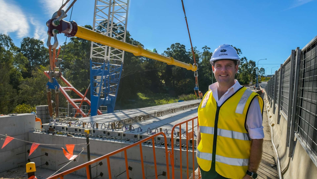 Mayor Jon Raven watches as the bridge decks are lifted into place at Loganlea Road.