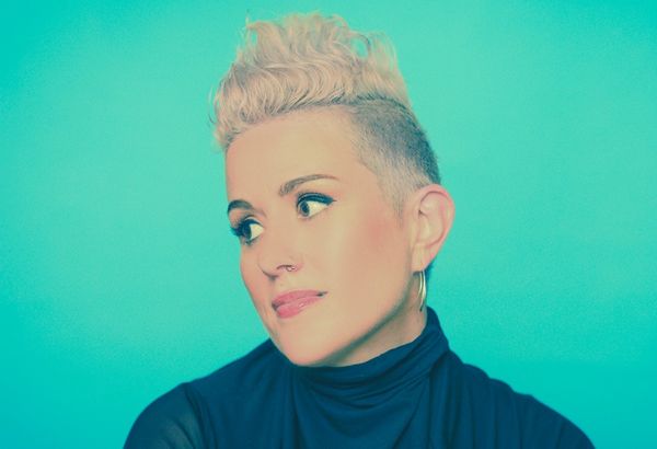 Katie Noonan headshot - woman with blonde cropped hair looking sideways.