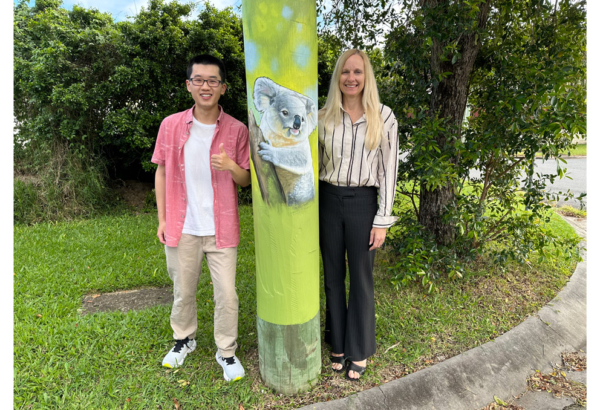 An image of Cr Stemp and Shailer Park resident Benjamin Liu with one of the new Moogara St murals.