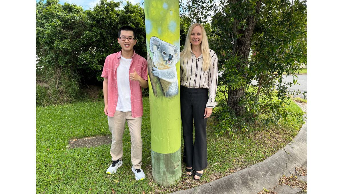 An image of Cr Stemp and Shailer Park resident Benjamin Liu with one of the new Moogara St murals.