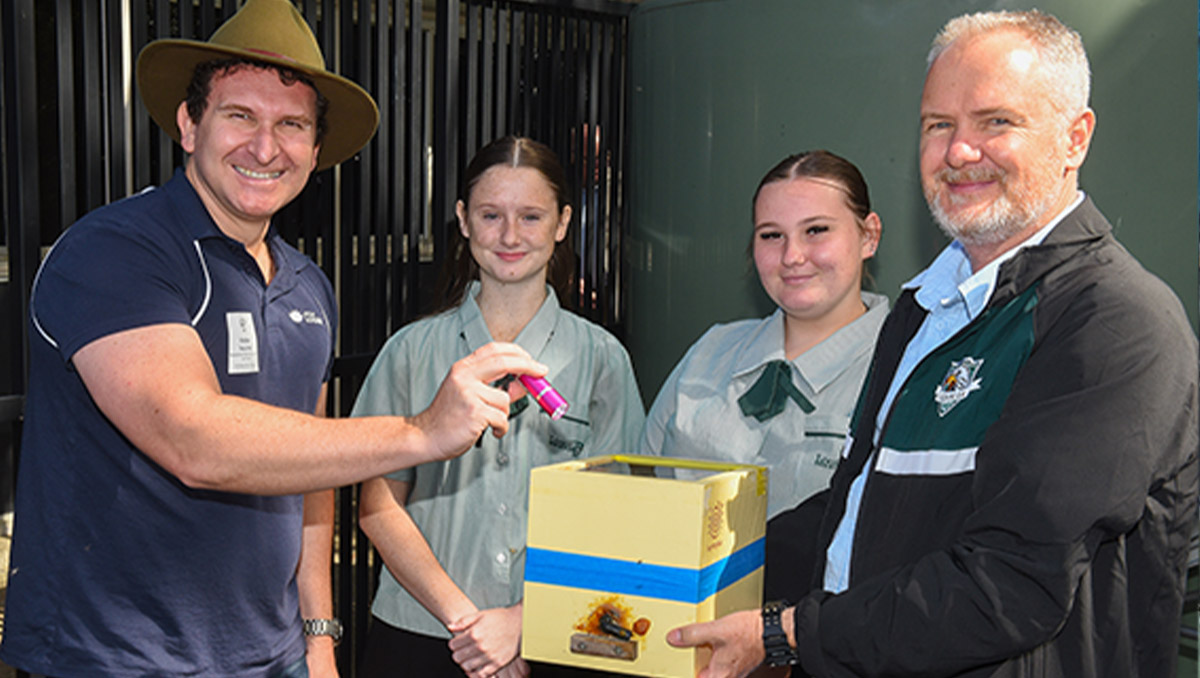An image of Cr Tony Hall inspecting a native beehive with Loganlea State High School’s Head of Science and Maths Andrew Steele and students Kaytona and Abigail.