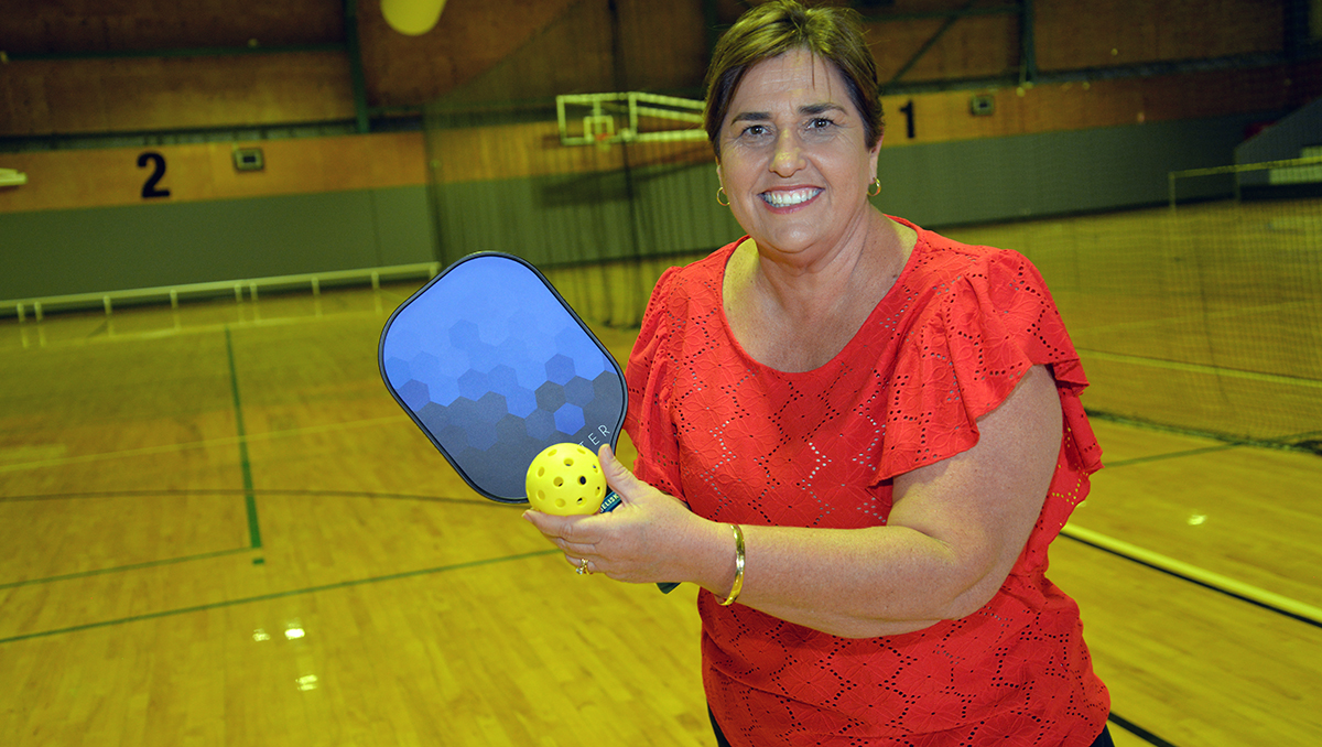An image of Cr Karen Murphy getting ready to try pickleball at Mount Warren Sports and Fitness Centre.