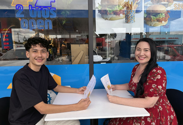 An image of Cr Mindy Russell catches up with former Mabel Park State High student and young entrepreneur Mo Alizadeh at 2 Bros cafe at Slacks Creek.
