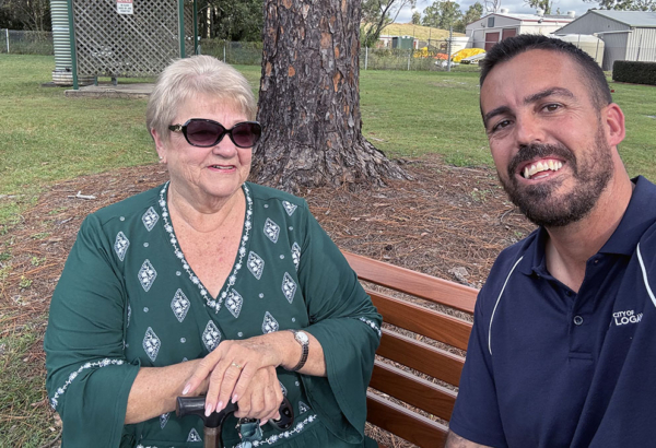 An image of Cr Nathan St Ledger and Mavis Brown on the new bench seat at Logan Village Cemetery.
