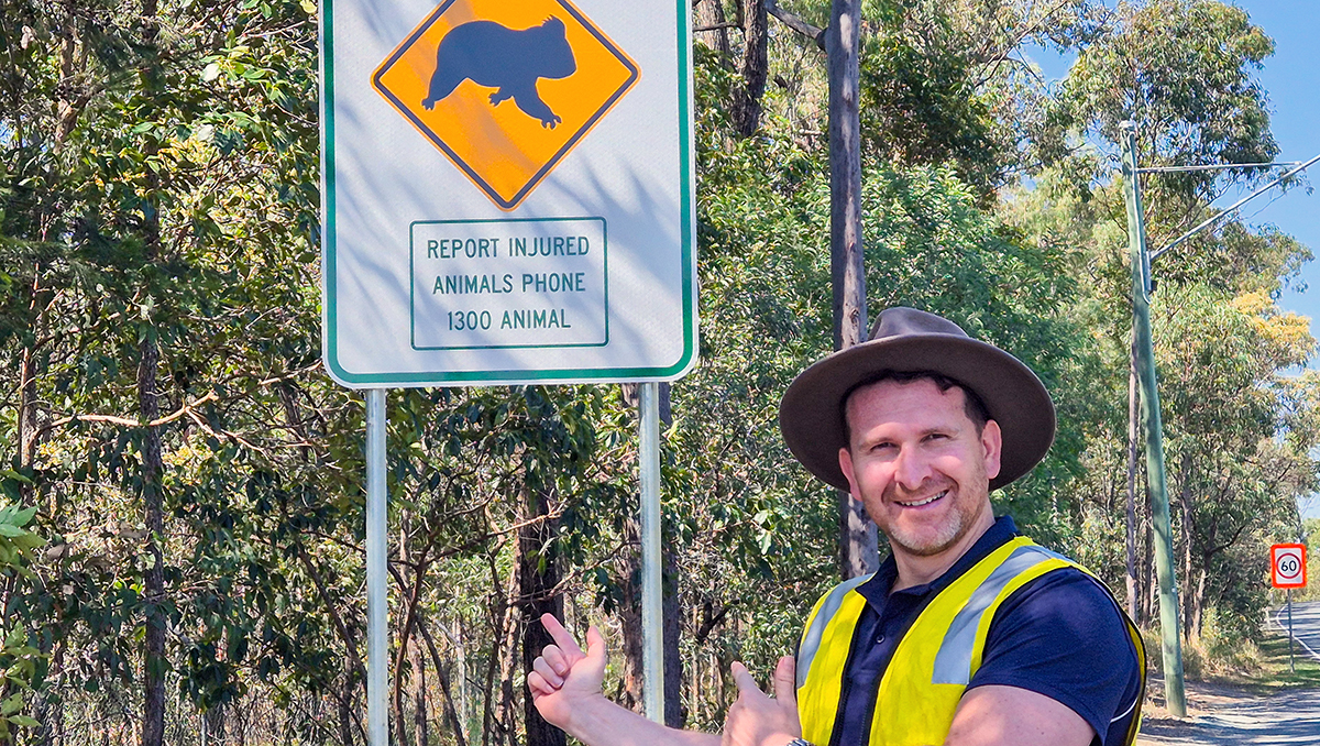 aN IMAGE OF Cr Tony Hall with one of the wildlife advisory roadside signs.
