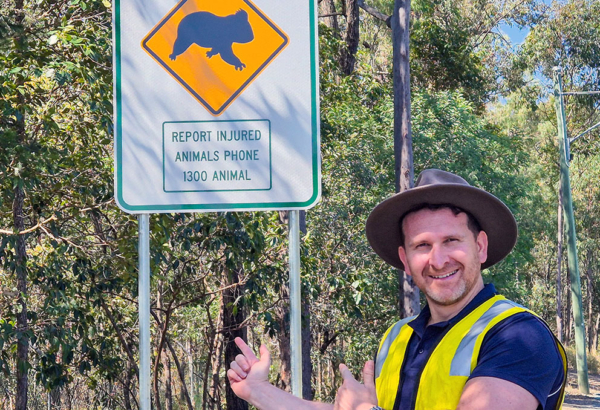 aN IMAGE OF Cr Tony Hall with one of the wildlife advisory roadside signs.