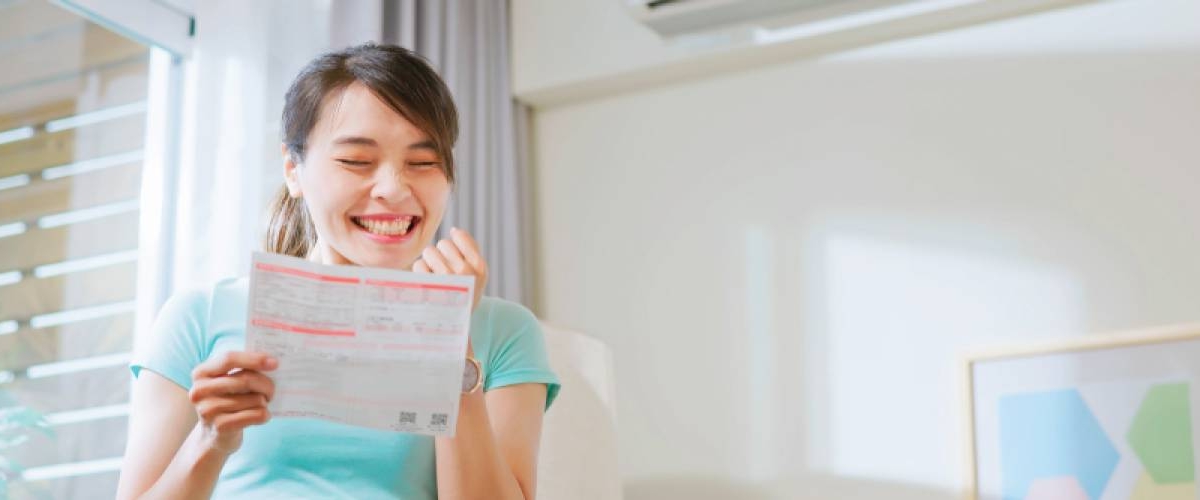 Woman smiling while looking at power bill