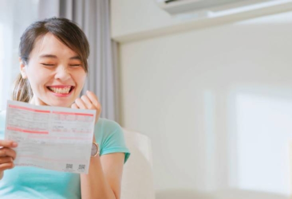 Woman smiling while looking at power bill