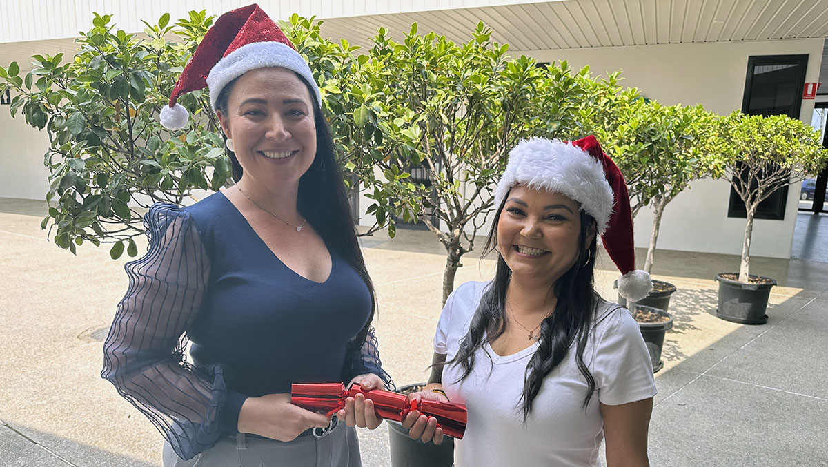 Cr Mindy Russell (left) and Hope Centre's Melly Possumah get into the Christmas spirit. An image of Cr Mindy Russell (left) and Hope Centre's Melly Possumah getting into the Christmas spirit with a bon bons