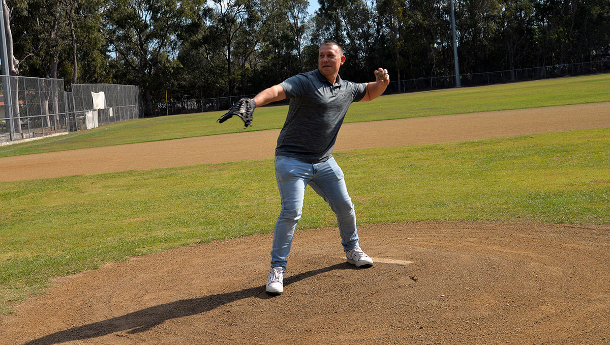 An image of Cr Tim Frazer throwing a ceremonial opening pitch at Southern Stars Baseball Club.
