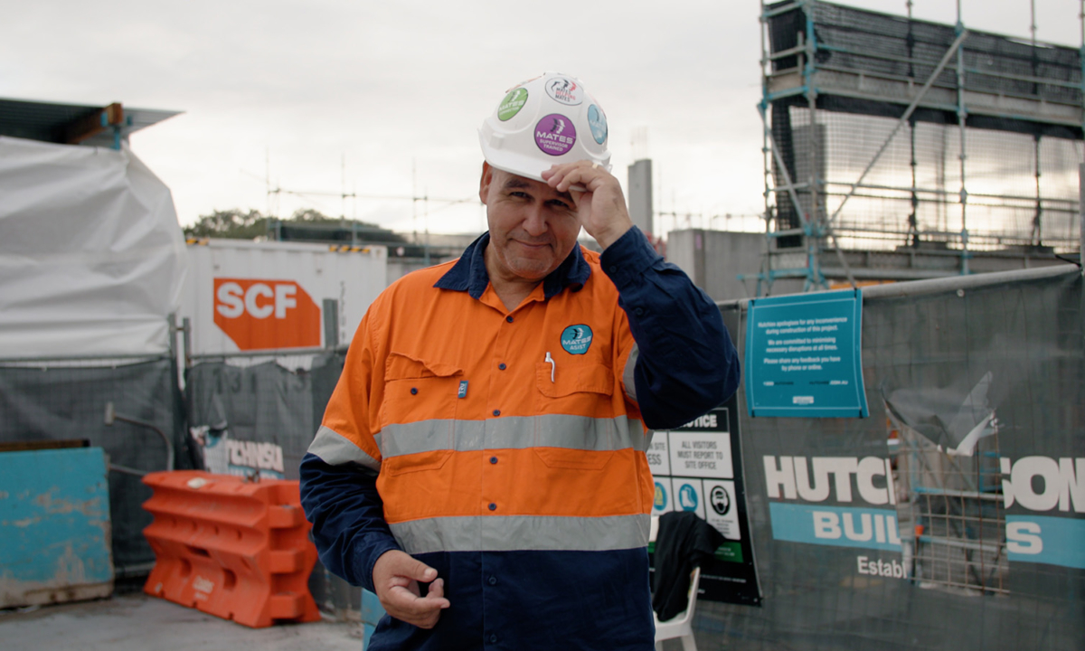 Justin Grange dressed in high vis visits a work site